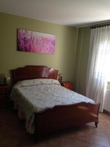 1 dormitorio con 1 cama y una pintura en la pared en Pension Meson Paz, en Puentedeume