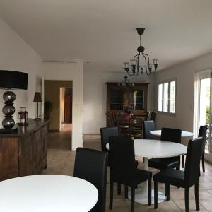 comedor y sala de estar con mesa blanca y sillas en Chambre d'hôtes Costa Belle, en Lunel-Viel