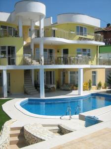 una casa grande con piscina frente a ella en Eli Guest House, en Balchik
