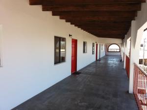 an empty corridor in a building with a red door at Adanesne Apartments in Ensenada