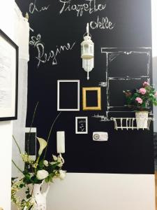 a room with a black wall with pictures and flowers at La Piazzetta delle Regine in Rome