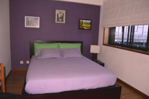 sypialnia z dużym łóżkiem i fioletowymi ścianami w obiekcie Matosinho's Palace w mieście Matosinhos