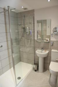 a bathroom with a shower and a toilet and a sink at Burt's Hotel in Melrose