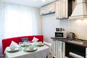 モスクワにあるLux Apartment Uralskayaの小さなキッチン(テーブル、赤いソファ付)
