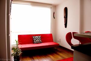 um sofá vermelho num quarto com uma janela em Chic space by Unicentro em Bogotá