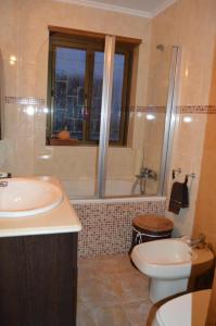 een badkamer met een wastafel, een toilet en een bad bij Matosinho's Palace in Matosinhos