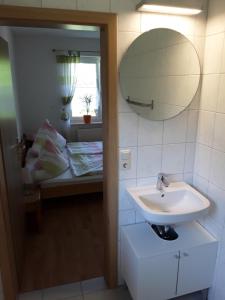 Un baño con lavabo, cama y espejo. en Haus Edzards, en Neuharlingersiel 29 fotos más