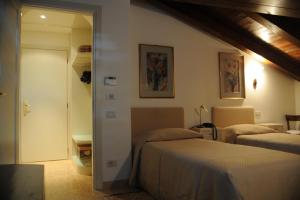 una camera d'albergo con due letti e un corridoio di Al Melograno - Room & Breakfast a Bologna
