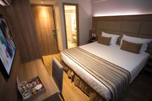 Un pat sau paturi într-o cameră la Petit Rio Hotel