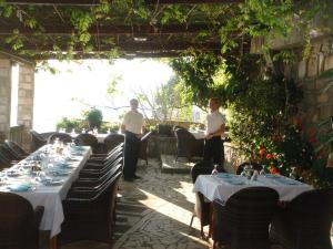 two men standing in a patio with tables and chairs at Apartments Grispolis in Tivat