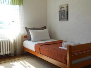 a bedroom with a bed with orange blanket and a window at Apartment Djukovic in Petrovac na Moru