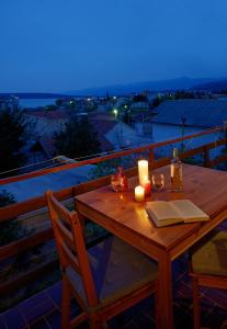 una mesa de madera con velas y copas de vino en Apartments Mira, en Gornji Karin