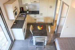 a kitchen with a table and chairs in a room at Bellavistaloc' in Porto-Vecchio
