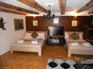 a living room with two couches and a tv at Apartment Djukovic in Petrovac na Moru