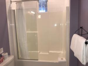 La salle de bains est pourvue d'une douche avec une porte en verre. dans l'établissement The Inn at Tough City, à Tofino