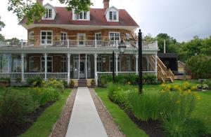 a large house with a walkway in front of it at Chez Truchon Bistro-Auberge in La Malbaie