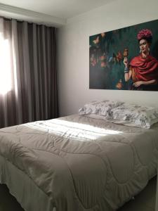 uma cama num quarto com um quadro na parede em Top Floripa Apartment em Florianópolis