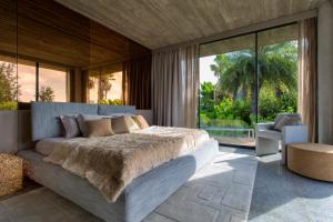 a bedroom with a large bed and a large window at Villa Islander in Providenciales