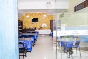 a restaurant with blue tables and chairs and a tv at Pousada das Pedras in Toque Toque Pequeno