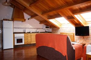 a kitchen with a white refrigerator and a stove at Apartamentos Casa Cerolleiro in Castropol