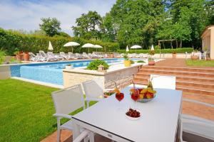 una mesa blanca y sillas junto a una piscina en Apartments Tena, en Poreč