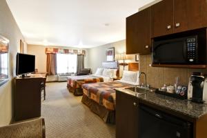 a hotel room with two beds and a kitchen at Canalta Camrose in Camrose