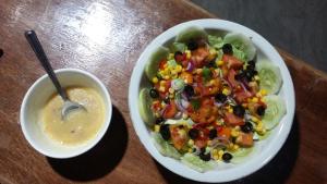 a bowl of salad next to a bowl of soup at Sablayan Paraiso Beach Resort in Sablayan