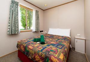 A bed or beds in a room at Rainbow Pines Tourist Caravan Park