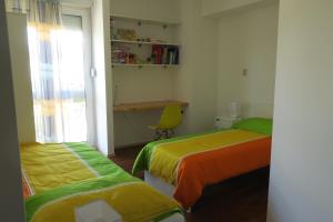 una habitación con dos camas, un escritorio y una ventana en Apartment Veseli, en Split