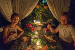 Ein Mann und eine Frau sitzen an einem Tisch mit Essen in der Unterkunft Bike and Tours Bed and Breakfast in Lahad Datu