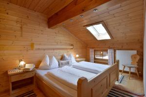 ein Schlafzimmer mit einem Bett in einem Blockhaus in der Unterkunft Hacklhof in Kössen