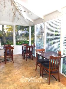 a dining room with chairs and a table and windows at The Devereux Boutique Hotel in Auckland