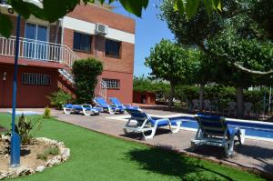 una fila de tumbonas junto a una piscina en Villa Lagem, en Cubelles