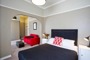a bedroom with a bed and a red chair at Katoomba Hotel in Katoomba