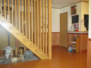 uma escada de madeira numa casa com um quarto em Ryokan Fuji em Tóquio