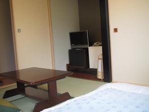 - un salon avec une table et une télévision dans l'établissement Ryokan Fuji, à Tokyo