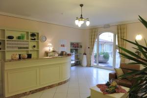 a lobby with a counter and a living room at Hotel Plazza in Porcari