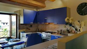 a kitchen with blue cabinets and a table and a clock at Ca' Le Erbe in Fano