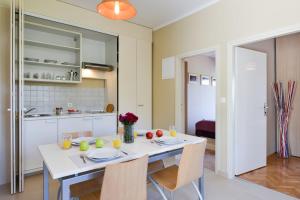 a kitchen and dining room with a white table and chairs at Cecilia Apartments in Lun