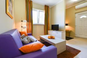 a living room with a purple couch and a coffee table at Cecilia Apartments - stunning sea views and relaxing Mediterranean getaway in Lun