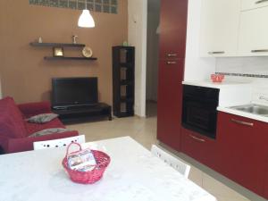 a kitchen and living room with a basket on the counter at Le cisterne Holiday Home in Manfredonia