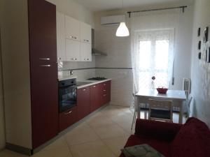 a kitchen with brown cabinets and a stove top oven at Le cisterne Holiday Home in Manfredonia