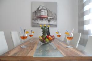 - une table en bois avec un bol de fruits et des verres à vin dans l'établissement Apartment Playa, à Novigrad