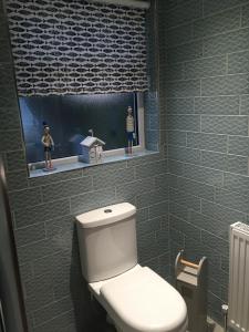 La salle de bains est pourvue de toilettes blanches et d'une fenêtre. dans l'établissement Salmon House, à Stornoway