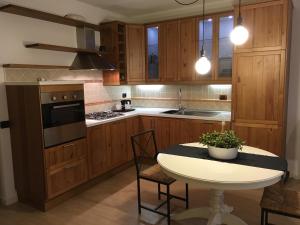 una cucina con armadi in legno e tavolo con sedie di Appartamento al Fiume a Riva del Garda