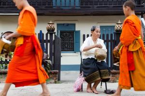 a woman sitting on a chair with two other people at Villa Chitdara in Luang Prabang