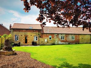 an old brick house with a green lawn in front of it at The Old Granary in York