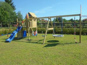 um parque com um parque infantil com escorrega e baloiços em Ferienwohnungen Eva Lange em Uhldingen-Mühlhofen