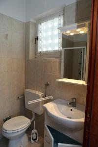 a bathroom with a white toilet and a sink at Guesthouse Meri in Fažana