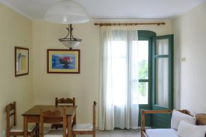 ヴロンダトスにあるKyveli Hotel Apartmentsのテーブルと窓のあるダイニングルーム